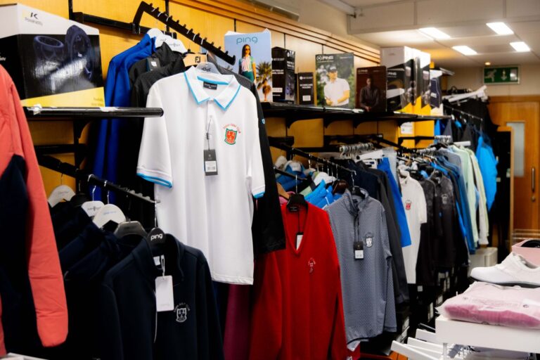 Golf shop interior with various clothing items and accessories on display.