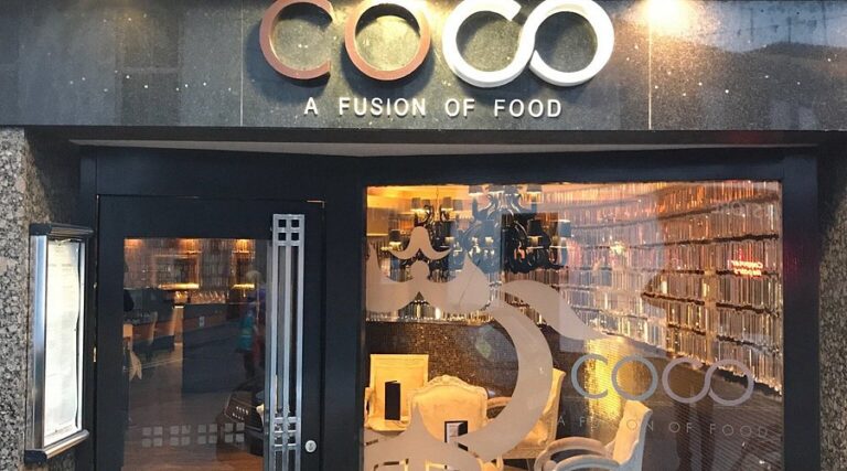 Exterior view of COCO restaurant with modern design, glass windows, and welcoming ambiance.