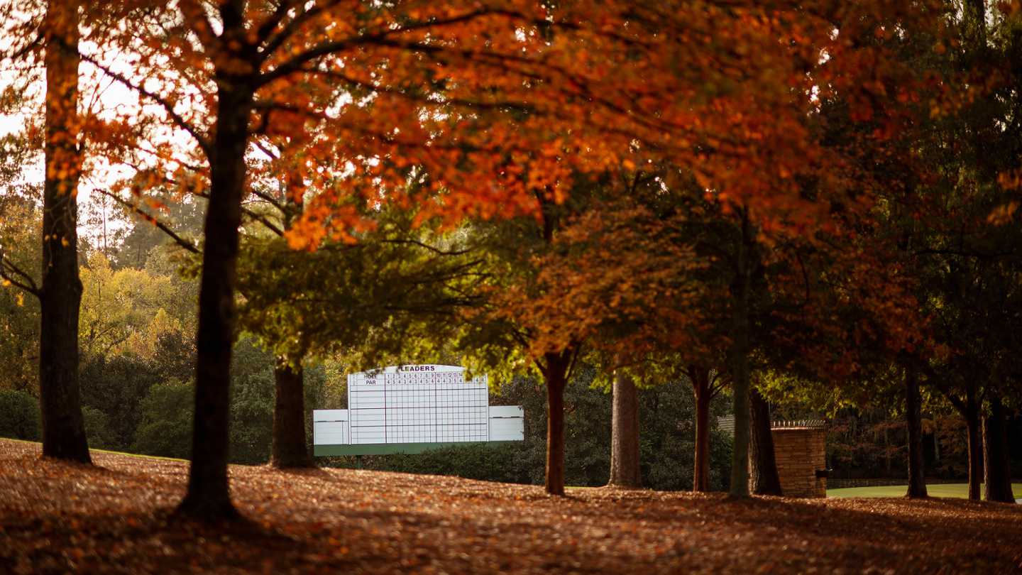 Autumn golf course landscape with leaderboard framed by vibrant fall foliage.