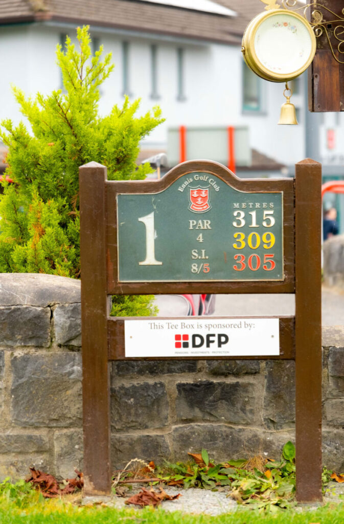 Golf course hole 1 sign at Ennis Golf Club showing distance and sponsor details.