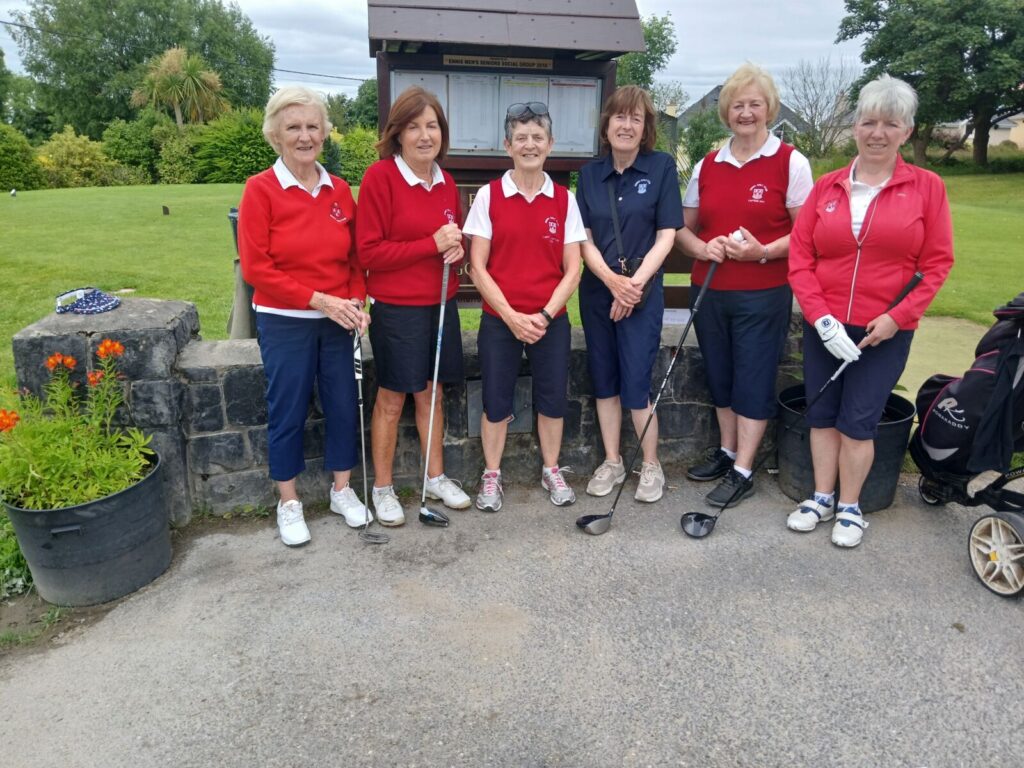 Senior women's golf team posing with clubs on a lush green course.